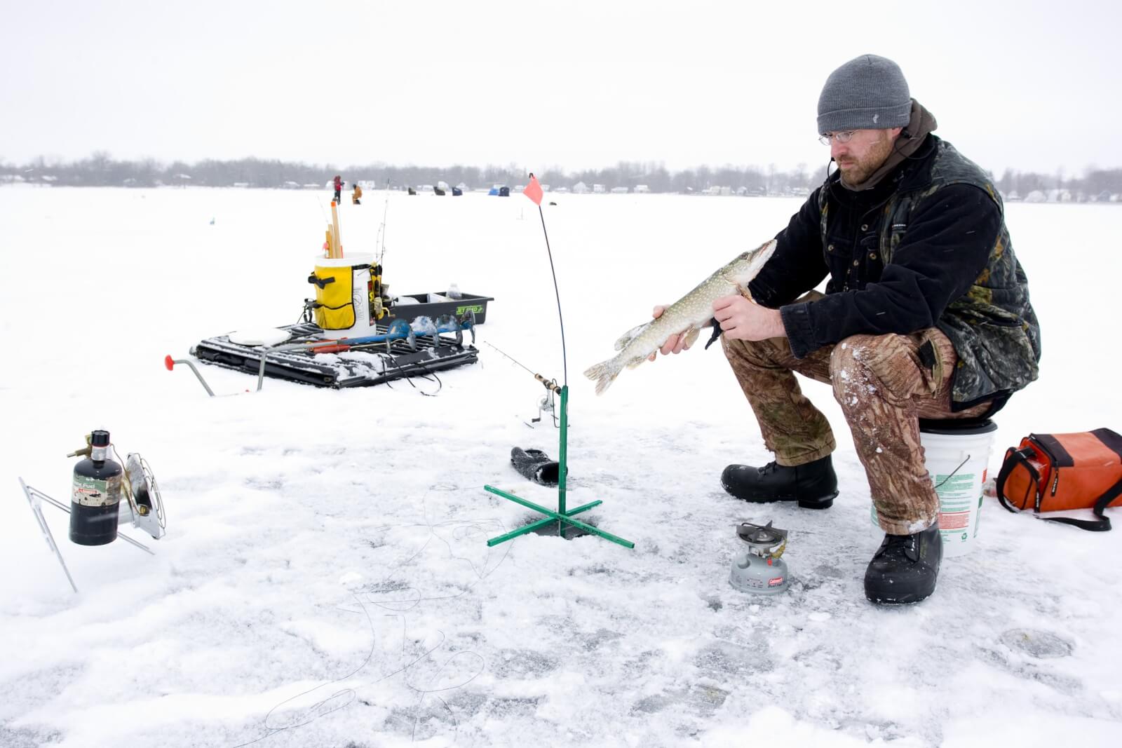 Man sitting on a bucket Ice Fishing