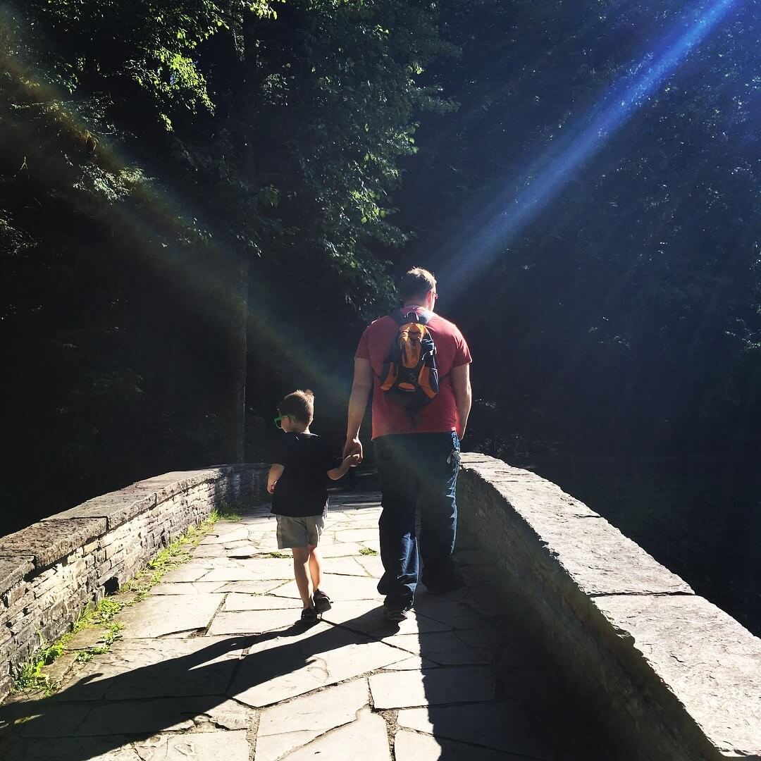 Father and son walking across a bridge
