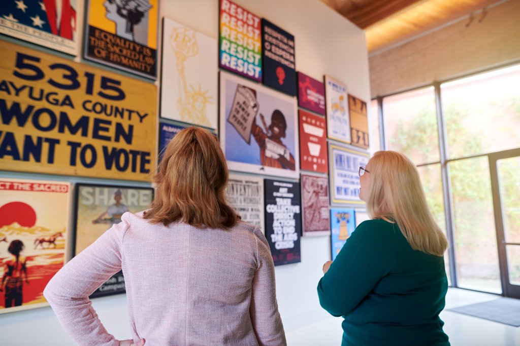 Two women looking at an exhibit of posters at the Equal Rights Heritage Center