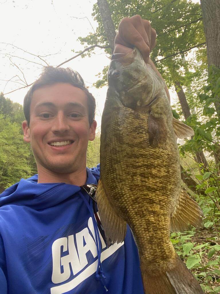 Man on a boat holding a fish