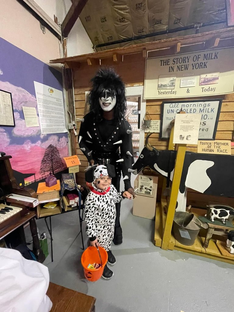 One adult in a Kiss Halloween Costume and  child in a Dalmatian Costume at the Ward O'Hara Museum tick or treating event
