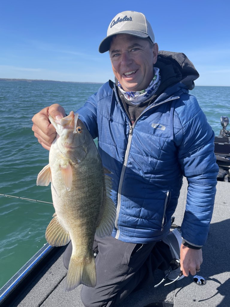 Man on a boat holding a fish