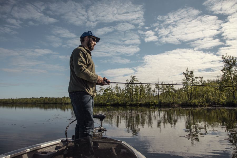 man standing on a boat fishing